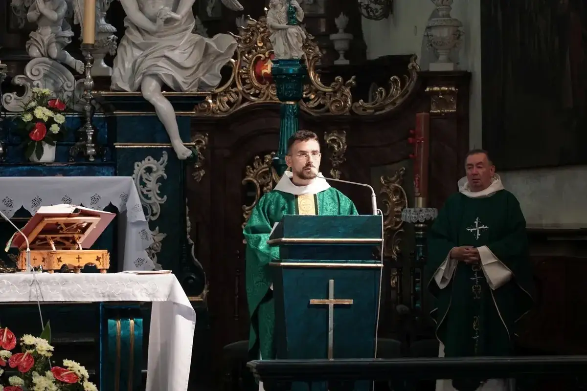 Dwóch księży w zielonych szatach liturgicznych. Jeden przemawia przy ambonie, drugi stoi obok. Zastanawiasz się, ile trwa msza w kościele?